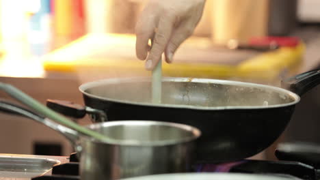 chef stirred the creamy sauce for pasta in a sauce pan