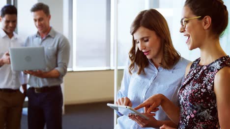 Executives-discussing-over-digital-tablet-and-laptop