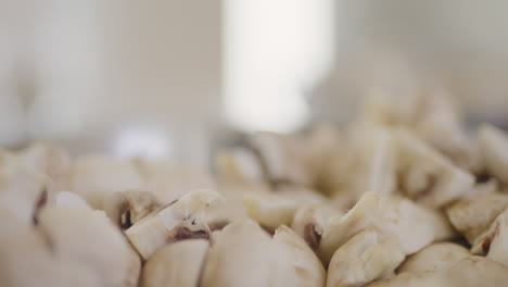 pouring sliced mushrooms into a bowl