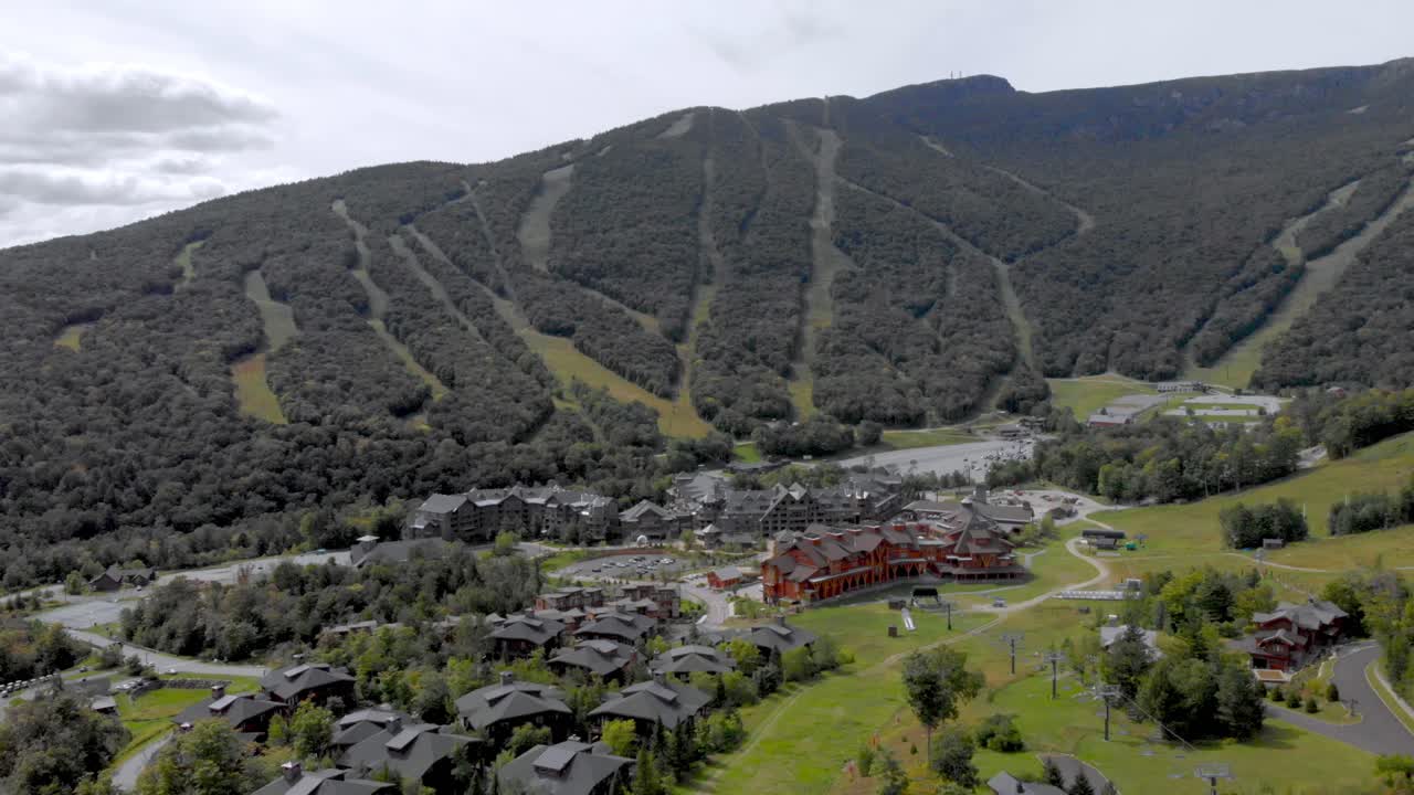 Drone wide shot pulling out over mountain resort.