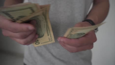 young man counting large amount of dollars in cash