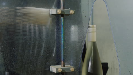 bottles of wine moving along the conveyor to the car where they are washed with water