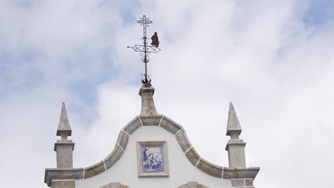 church pinnacle with weather vane and religious tile art