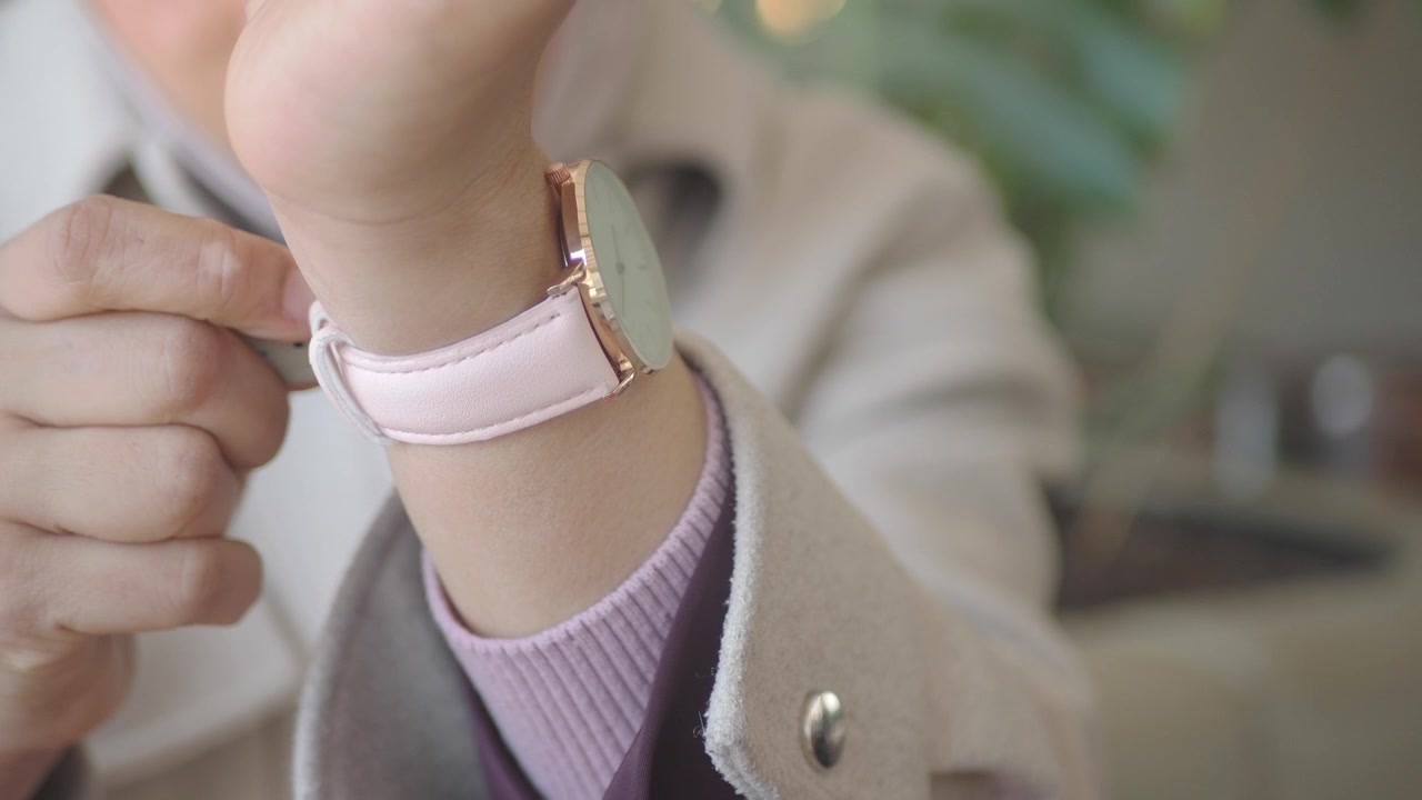 Close-up of Hand Adjusting Pink and Rose Gold Wristwatch