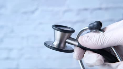 hand in glove holding a stethoscope