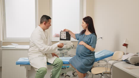 doctor discussing ultrasound with pregnant woman