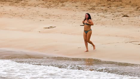 woman walking on the beach in a bikini