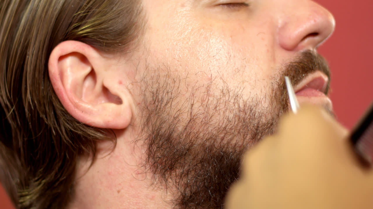 hombre recortando su barba con tijeras 4k