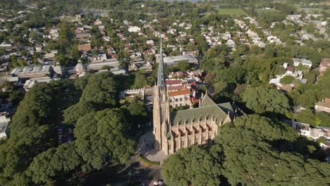 aerial orbit shot of san isidro cathedral surrounded by residential neighborhood near buenos aires city