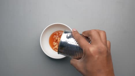 preserved canned tomato beans pouring into a bowl