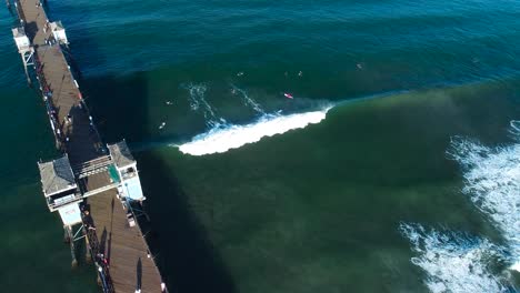 arial shot of oceanside pier and surfers with