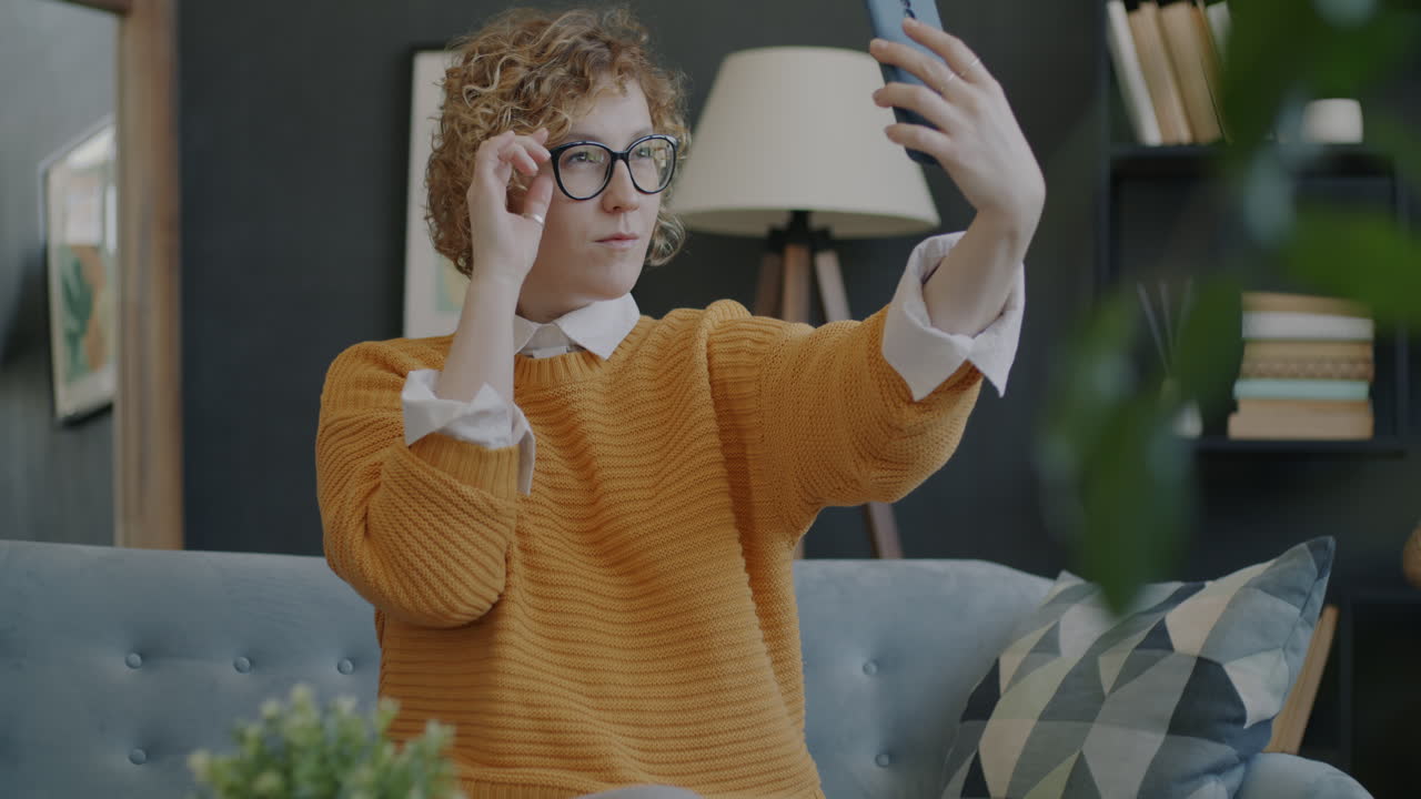 소파에서 셀피를 찍는 여자