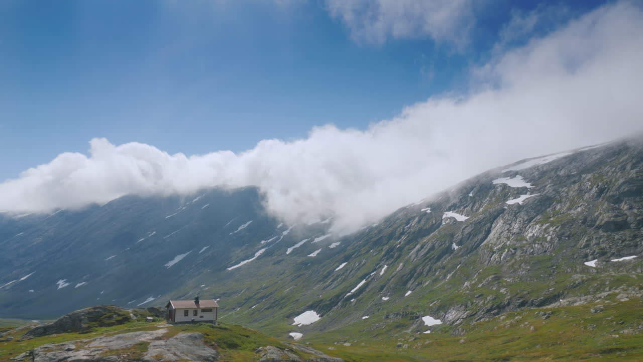 viaje cerca del pintoresco paisaje montañoso de noruega pase por una solitaria casa de madera vista desde el automóvil