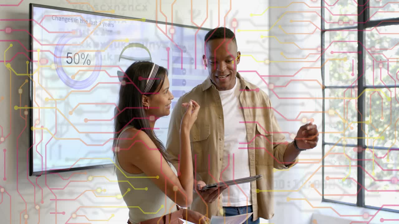 Woman explaining business data, causing man to check tablet while circuit overlay showing 50% chart