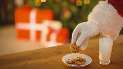 animación de la mano de santa claus tomando galletas de navidad del plato