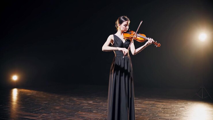 Elegant Woman Playing Violin on Stage Under Spotlights