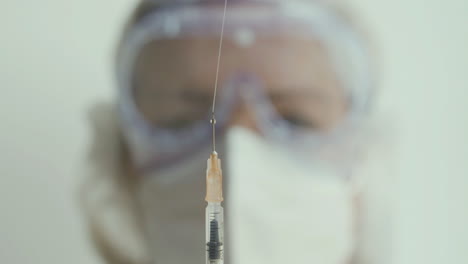 fotografía de cerca del médico arrojando la vacuna de la jeringa