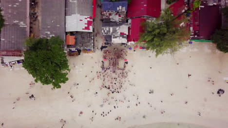 Aerial-Top-Down-Shot-of-Young-Adults-at-the-Beach-After-The-Full-Moon-Party-in-Koh-Phangan,-Thailand