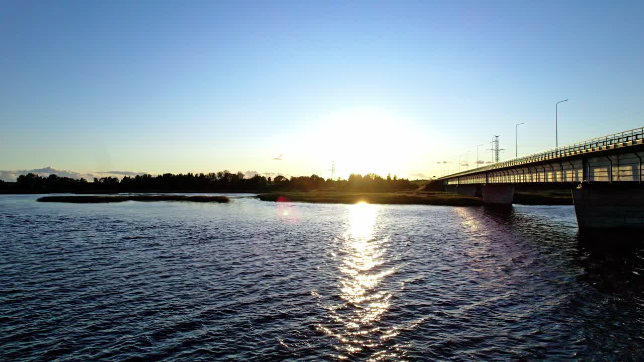 Sunset over the river in Latvia with a bridge and clear sky