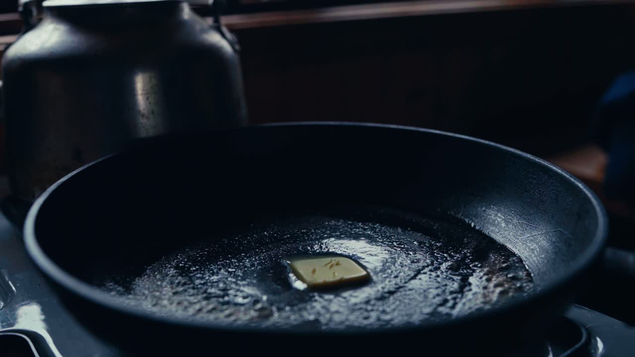 A Person is Melting Butter in a Pan on the Stove in a Rustic Kitchen in Reinsjøen, Åfjord, Trøndelag, Norway - Close Up