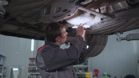 Mechanic-repairs-a-car-hanging-on-a-lift