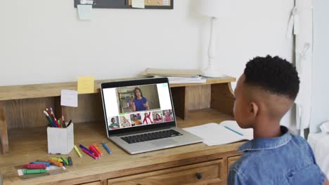 compuesto de un niño que usa una computadora portátil levantando la mano en una lección en línea, un maestro y una clase diversos en la pantalla