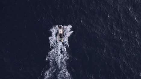 slomo de un barco de pesca que navega en grandes olas en mallorca, españa, desde el aire