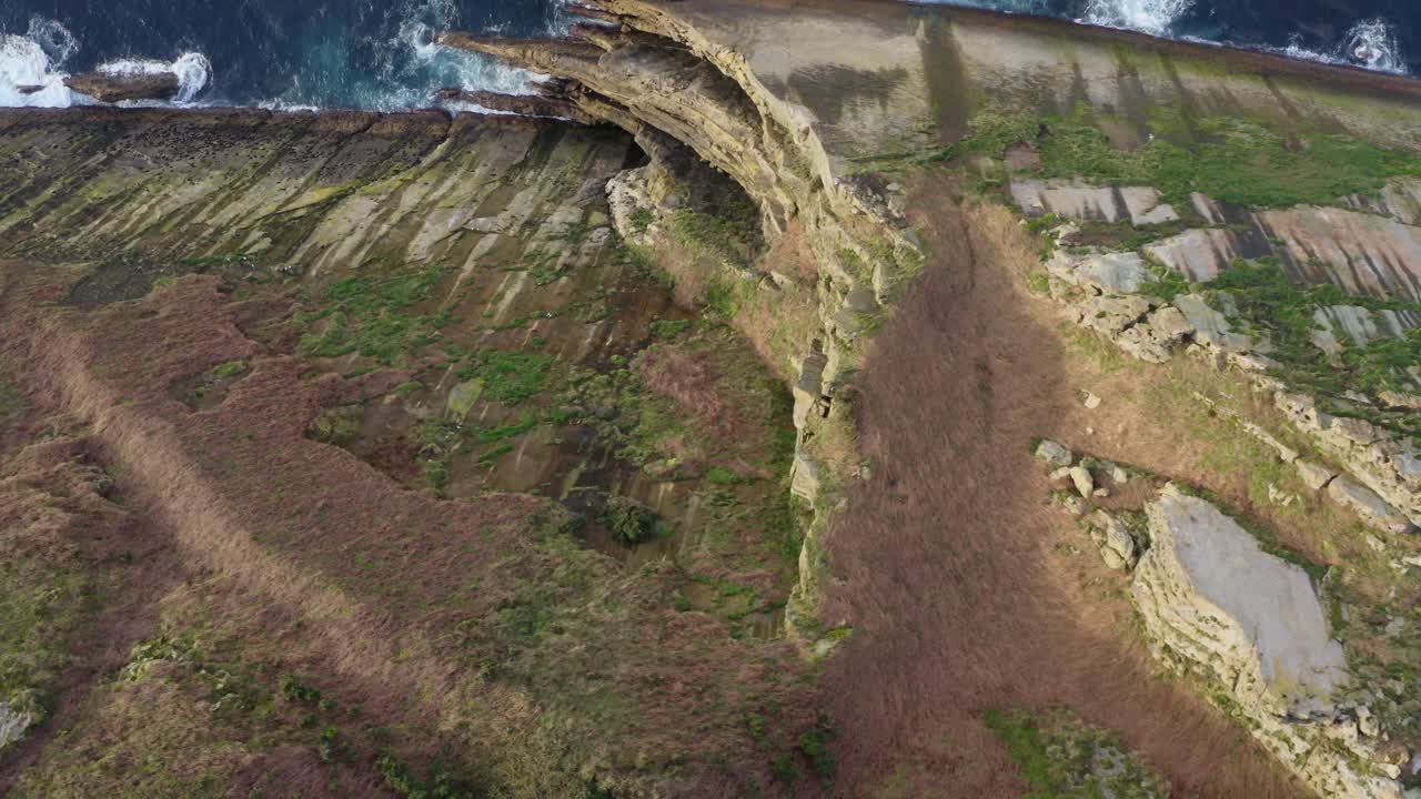 Top-down aerial pan reveals cliff's striking pointy side