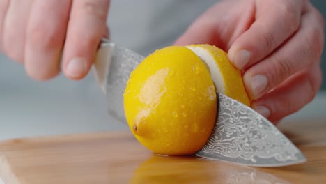 holding lemon steady while slicing it in half