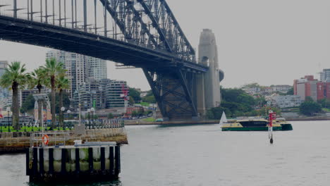 passenger ferry passes underneath the sydney harbour bridge in australia