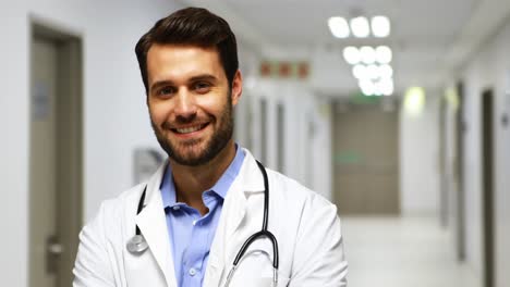 Portrait-of-smiling-male-doctor-in-corridor
