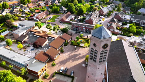 flight around the hexagon clock tower freestanding near the saint lawrence church. lovely panorama of vierlingsbeek, netherlands at backdrop