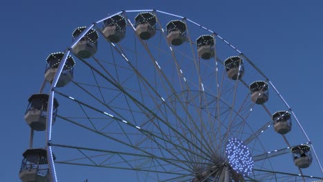 la rueda gigante en acción contra un cielo azul.