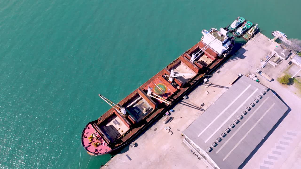 Aerial drone top view of containers cargo ship at industrial import-export port. Business logistic import and export freight transportation by container ship in open sea