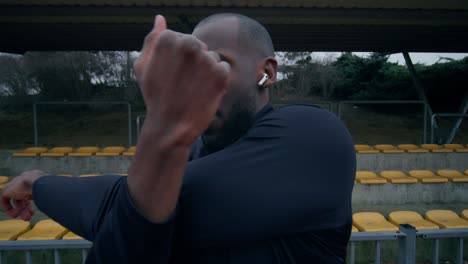 man stretching outdoors at a stadium