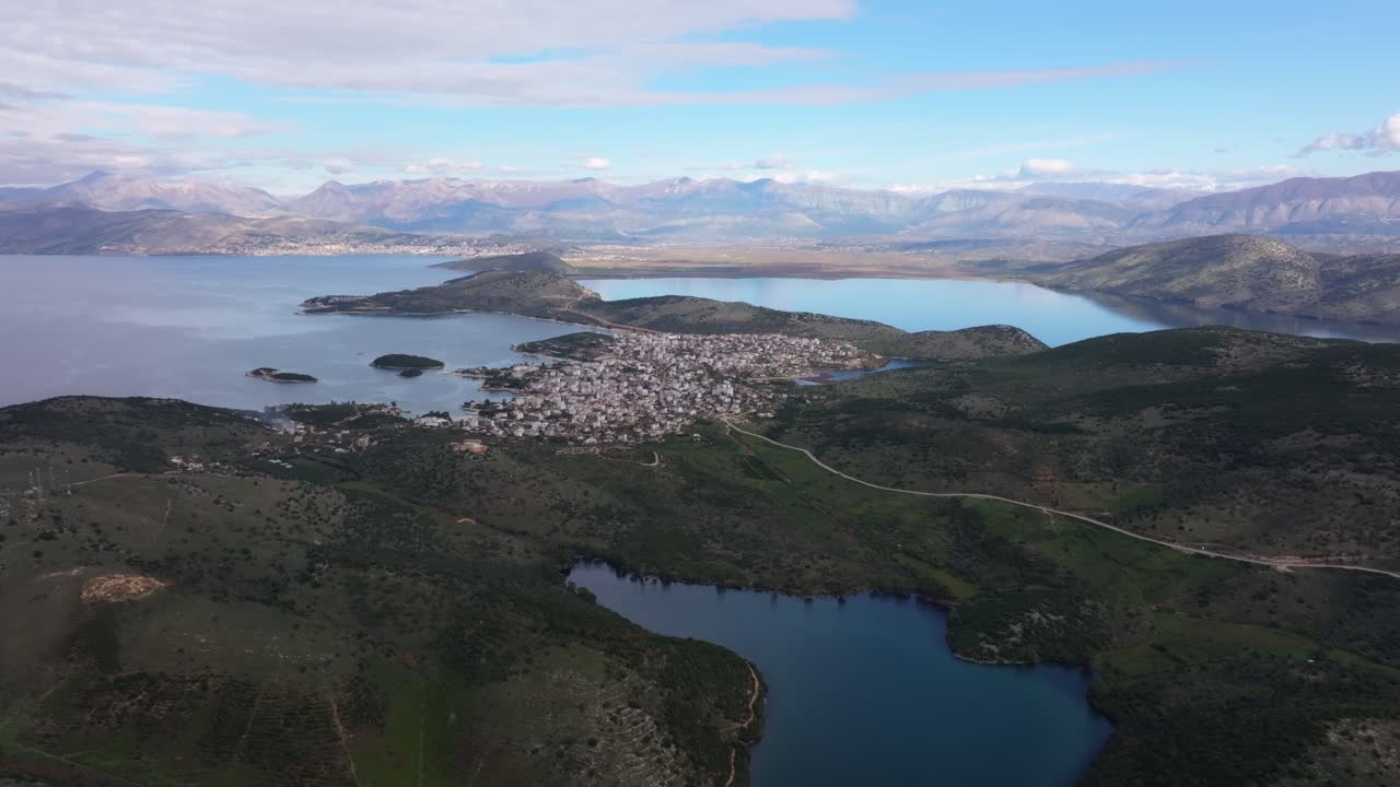 Dronezicht op de glinsterende wateren van Butrint die samenkomen met weelderige landschappen