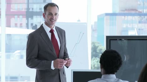 businessman reporting sales figures to his team