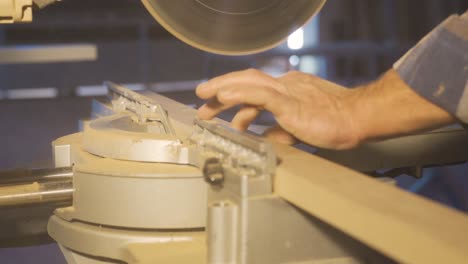 Carpenter-is-cutting-wood-with-electric-circular-saw.