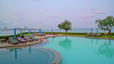 chair pool  or bed pool and umbrella around swimming pool with sea background - holidays and vacation concept