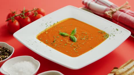 sopa de tomate en plato con hoja verde