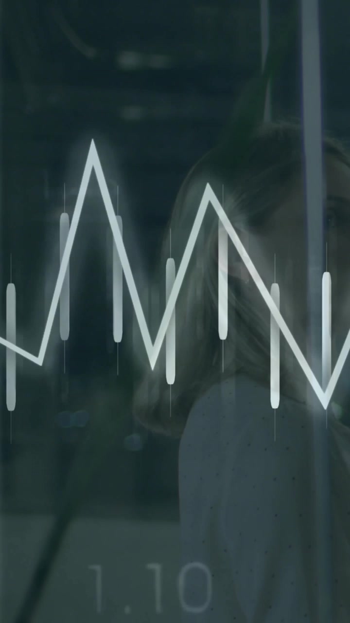 Vertical video: Tech woman behind glass tucking hair as overlay pulsing and animating graphs