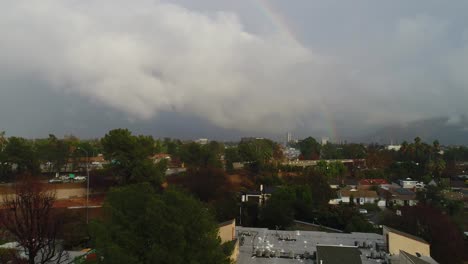 4K-Aerial-Drone-footage-of-Studio-City,-CA-with-rain,-cloudy-skies-and-a-rainbow