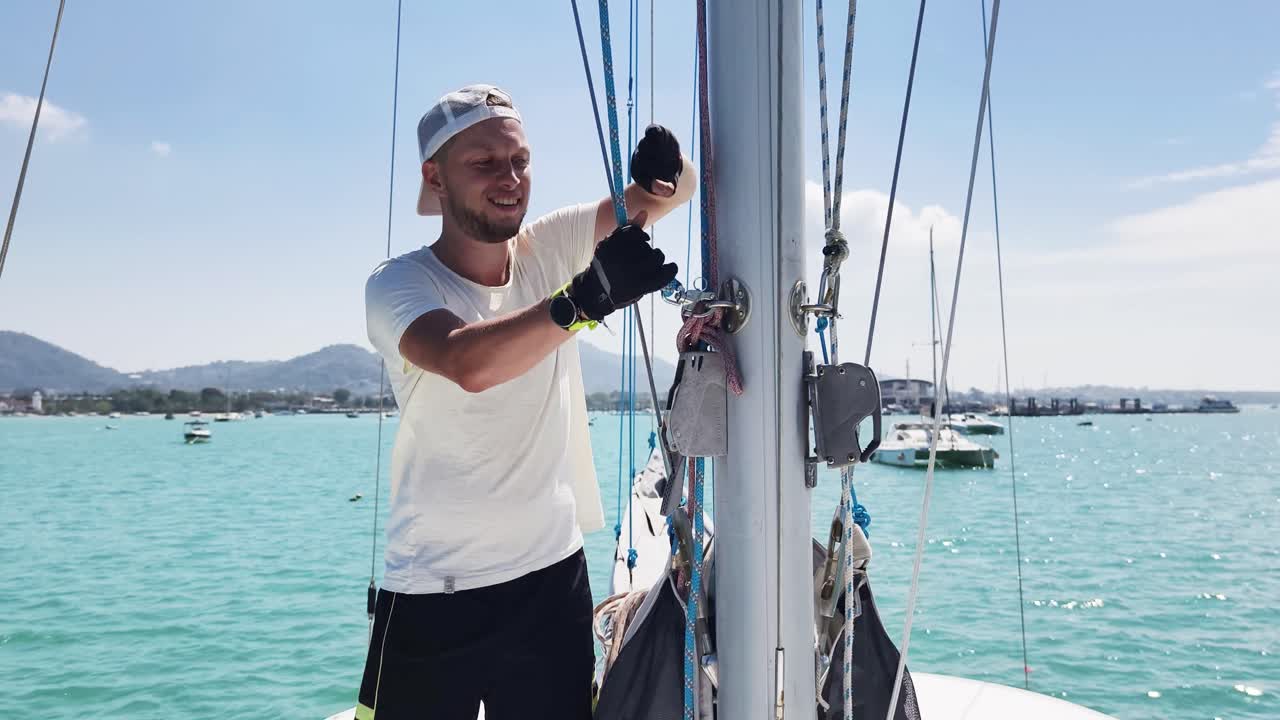 Hombre trabajando en el mástil de un velero