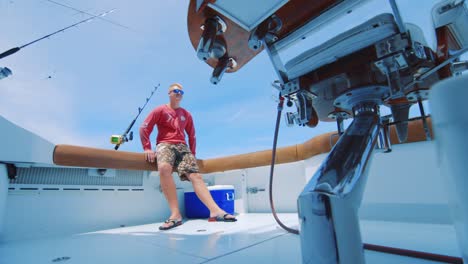 Guy-relaxing-in-the-back-of-a-yacht,-Low-Angle-SLOWMO