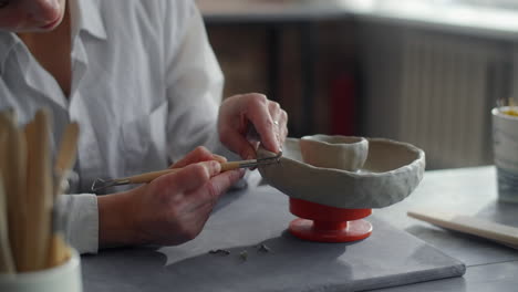 woman sculpting a clay bowl
