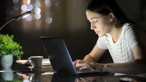 woman typing on laptop in the night