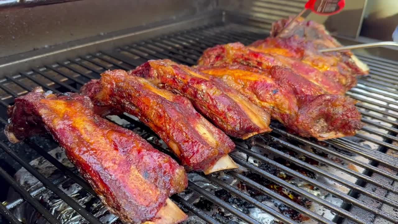 Checking The Internal Temperature Of BBQ Ribs On A Smoker