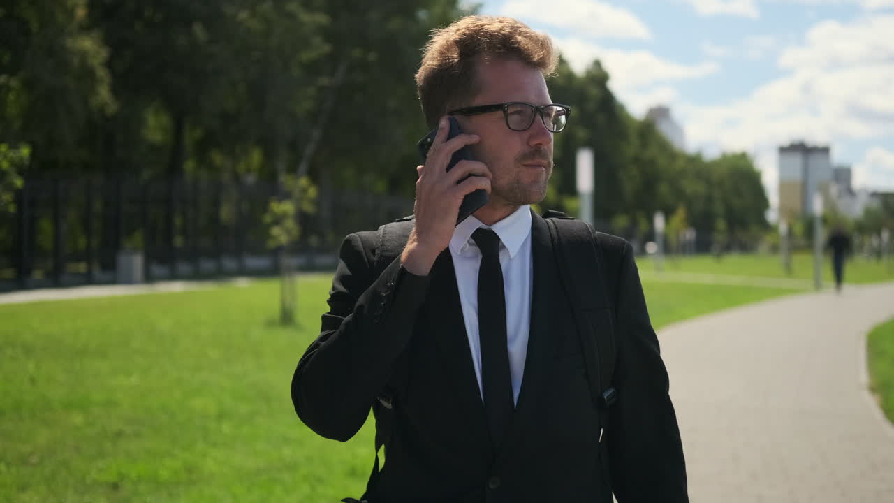 бизнесмен на телефонном звонке в парке