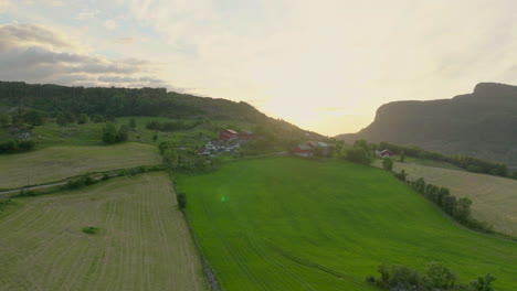 Vista-Aérea-De-La-Puesta-De-Sol-En-El-Entorno-Rural-Detrás-De-Las-Montañas