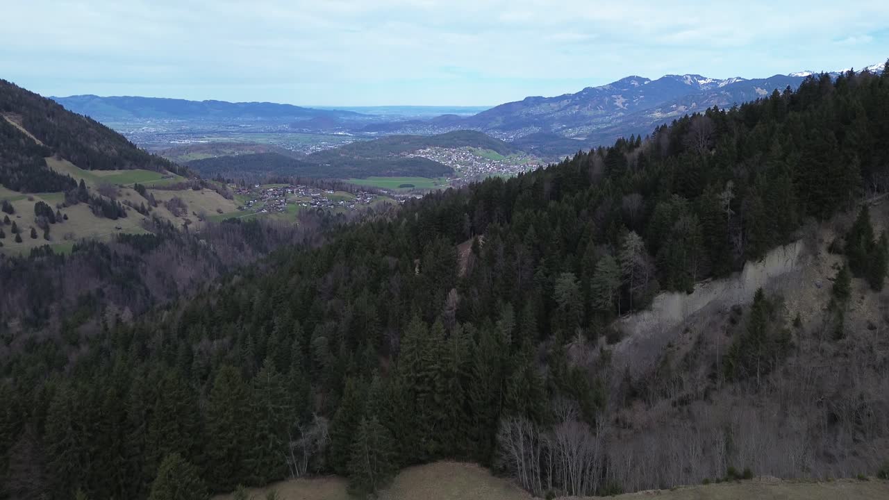 drone vuela en las montañas de austria sobre el bosque de pinos con vista sobre el valle